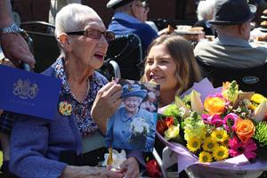 Hilda Fleming reads her card from the Queen on her 100th birthday with Aaron Court Care Home activities coordinator Amy Jones