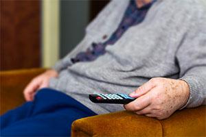 TV licence fee - an elderly man with TV remote in hand