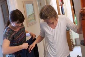Care home staff helping older people put on their coats so they can go outside and vote