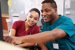 ​​social care workers look at a computer screen