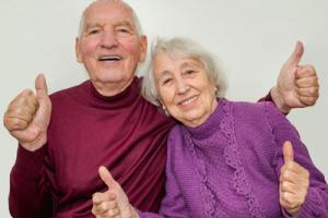 Old couple from Robinson House Care Home giving the thumbs up sign